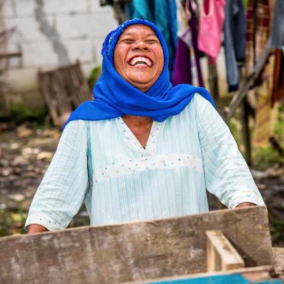 Lachende vrouw met blauwe hoofddoek