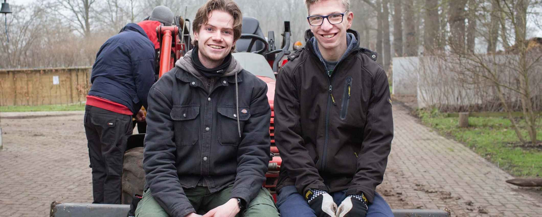 2 clienten van Reubezorg poseren op een werkbouwtuig